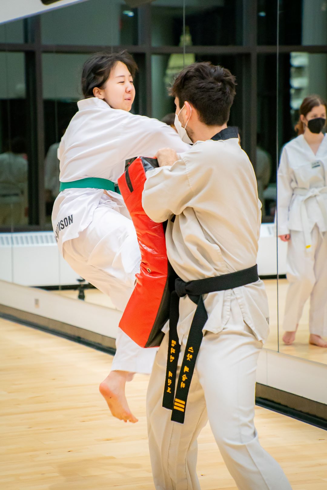 taekwondo athlete jumps and kicks a mat